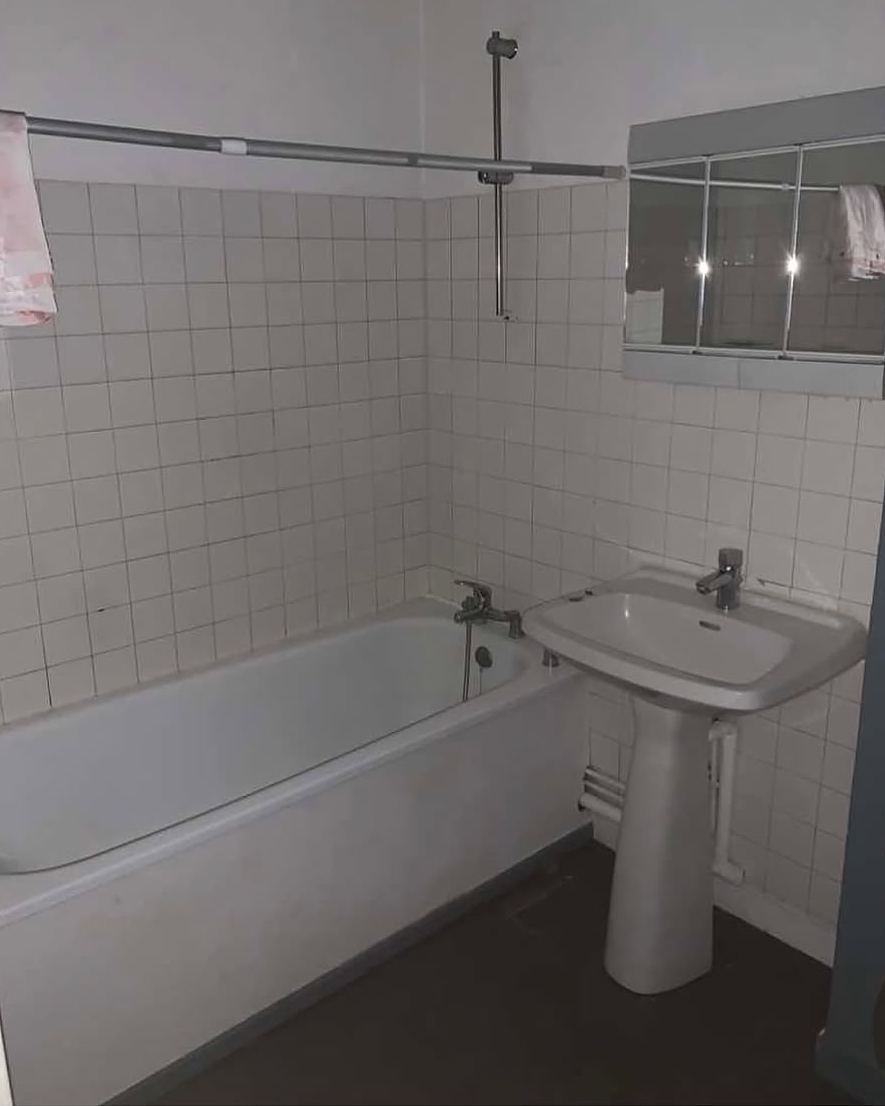 Avant travaux : salle de bain en faïence blanche avec baignoire encastrée et lavabo sur colonne.